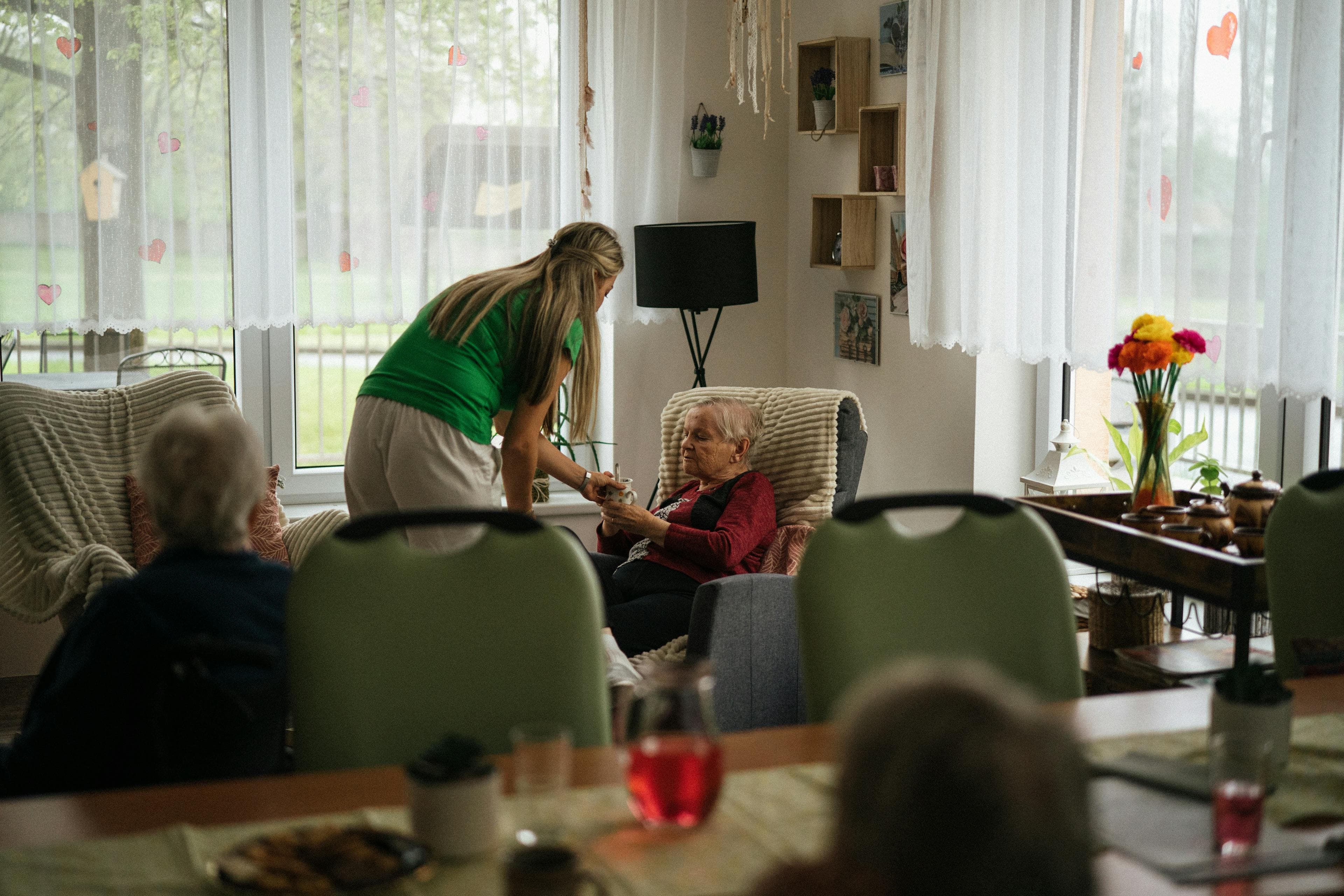 A compassionate caregiver helps an elderly client at home